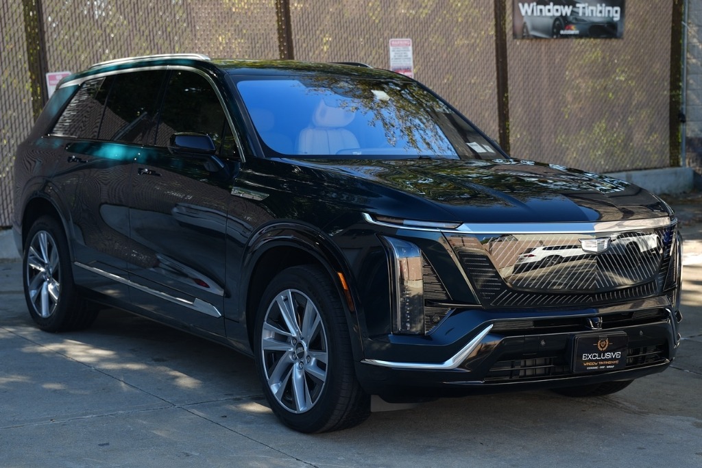 A black Cadillac SUV with professionally installed window tint parked outside Exclusive Window Tinting NYC in Staten Island, illustrating compliance with legal window tint limits in Staten Island under New York State regulations.